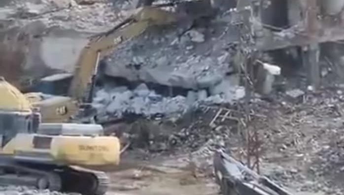 Hasarlı bina yıkım esnasında iş makinesinin üzerine çöktü